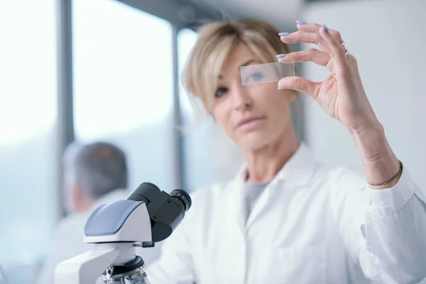 Женщина Исследователь Работающая Лаборатории Держит Руках Микроскоп Проверяет Образец — стоковое фото