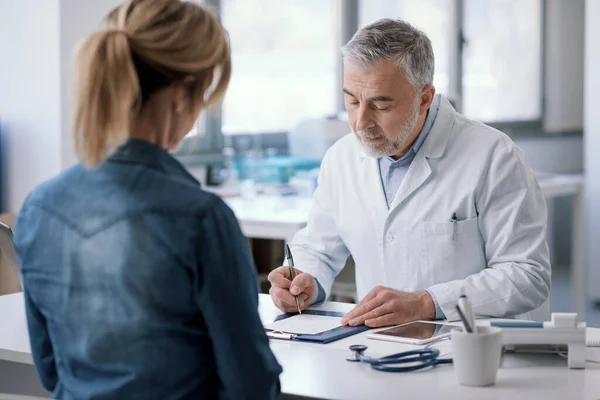 Doctor Sitting Desk His Office Writing Medical Prescription His Patient — ストック写真