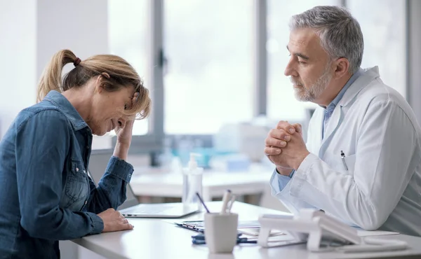 Doctor Sitting Desk Giving Bad Prognosis His Patient She Sad — Stock Fotó