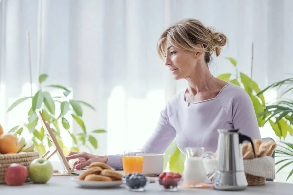 Mature Woman Having Relaxing Breakfast Home She Connecting Online Using —  Fotos de Stock