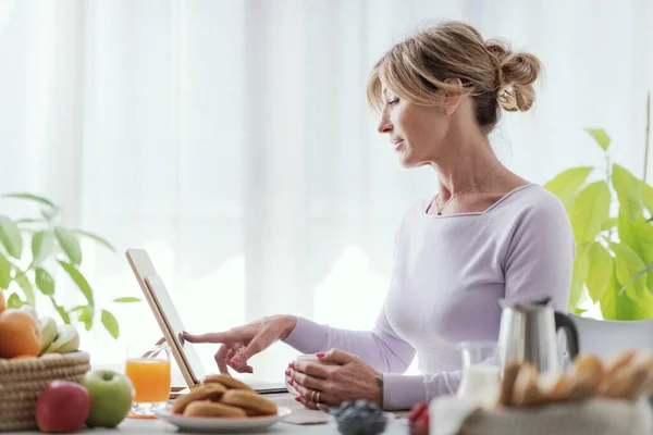 Mature Woman Having Relaxing Breakfast Home She Connecting Online Using —  Fotos de Stock