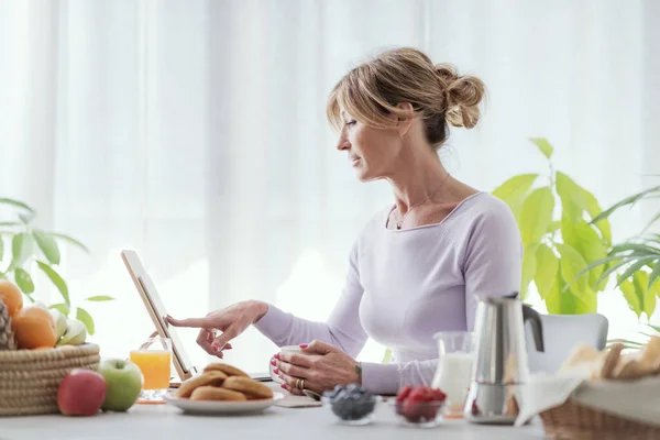 Mature Woman Having Relaxing Breakfast Home She Connecting Online Using — Zdjęcie stockowe