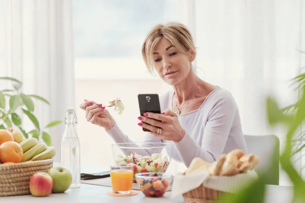 Woman Having Lunch Home Chatting Her Smartphone — Stok fotoğraf