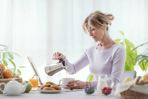 Mature Woman Having Breakfast Home She Pouring Coffee Cup Using —  Fotos de Stock