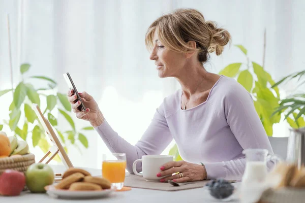 Mature Woman Having Breakfast Connecting Her Smartphone Home — Foto Stock