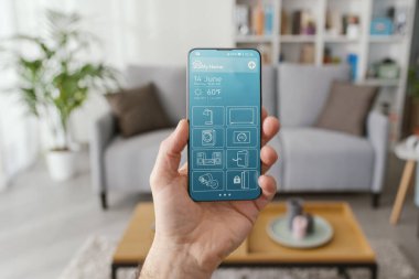 Woman managing smart devices in her home, smart home controls and menu interface on the smartphone display