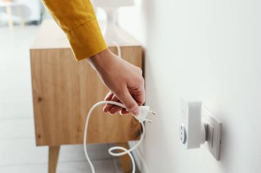 Woman plugging a device into a smart plug, virtual assistant and domotics concept
