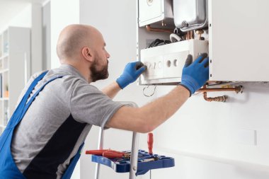 Professional qualified engineer testing a gas boiler after repair