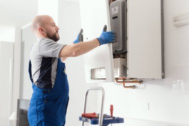 Professional engineer doing a boiler inspection at home