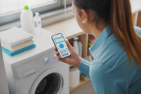 Woman Using Smart Washing Machine She Controlling Appliance Her Smartphone — Stock Fotó