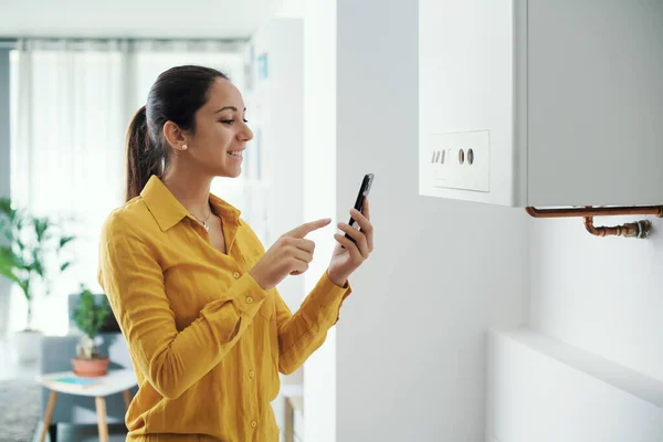 Woman Managing Programming Her Smart Boiler Using Her Smartphone Smart — Foto Stock