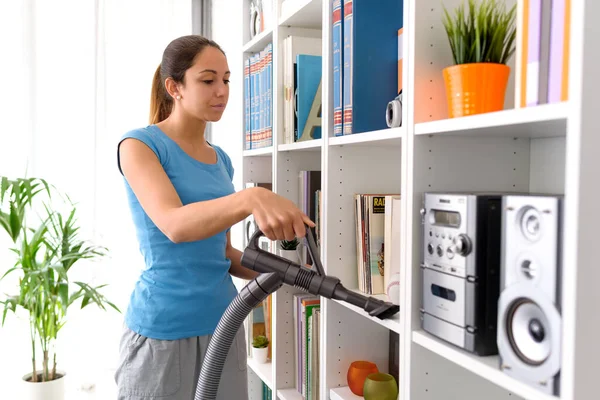 Woman Cleaning Bookshelf Home She Removing Dust Using Vacuum Cleaner — 图库照片