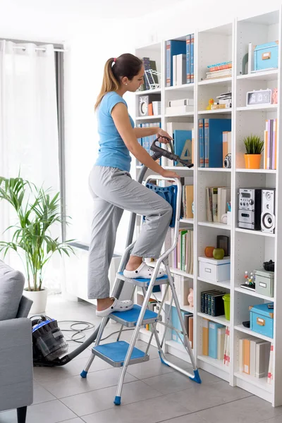 Woman Cleaning Bookshelf Home She Removing Dust Using Vacuum Cleaner — ストック写真