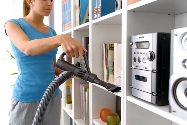 Woman Cleaning Bookshelf Home She Removing Dust Using Vacuum Cleaner — Stock fotografie