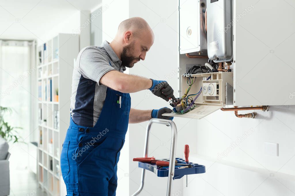 Professional qualified engineer servicing a natural gas boiler at home