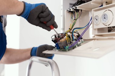 Professional qualified engineer servicing a natural gas boiler at home