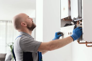 Professional qualified engineer testing a gas boiler after repair