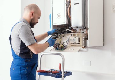 Qualified engineer checking flue gas emissions on a domestic gas boiler using a flue gas analyzer