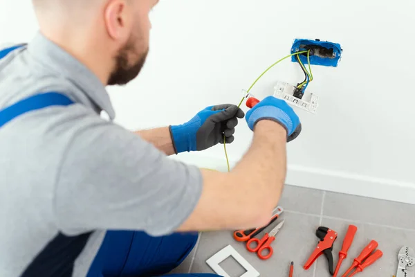 Professional electrician working on the electrical system, home improvement and repair concept