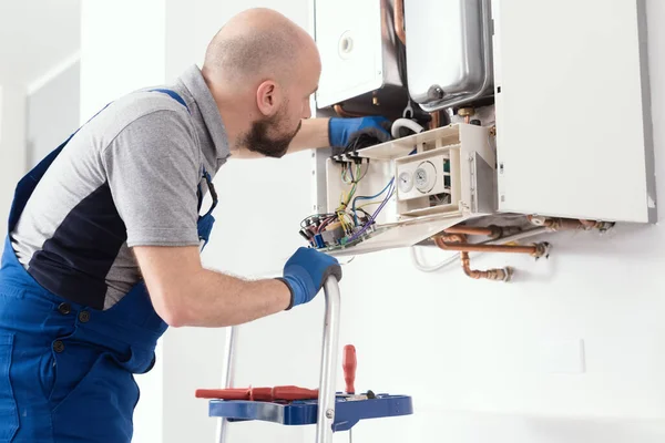 Professional boiler service: qualified technician checking a natural gas boiler at home