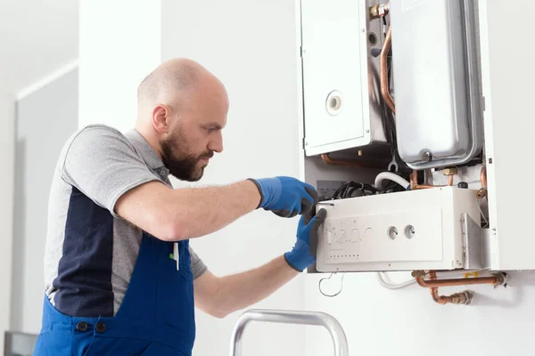 Professional boiler service: qualified technician checking a natural gas boiler at home