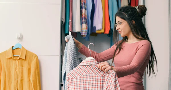 Young Happy Woman Holding Two Shirts Comparing Them She Choosing — Stok fotoğraf