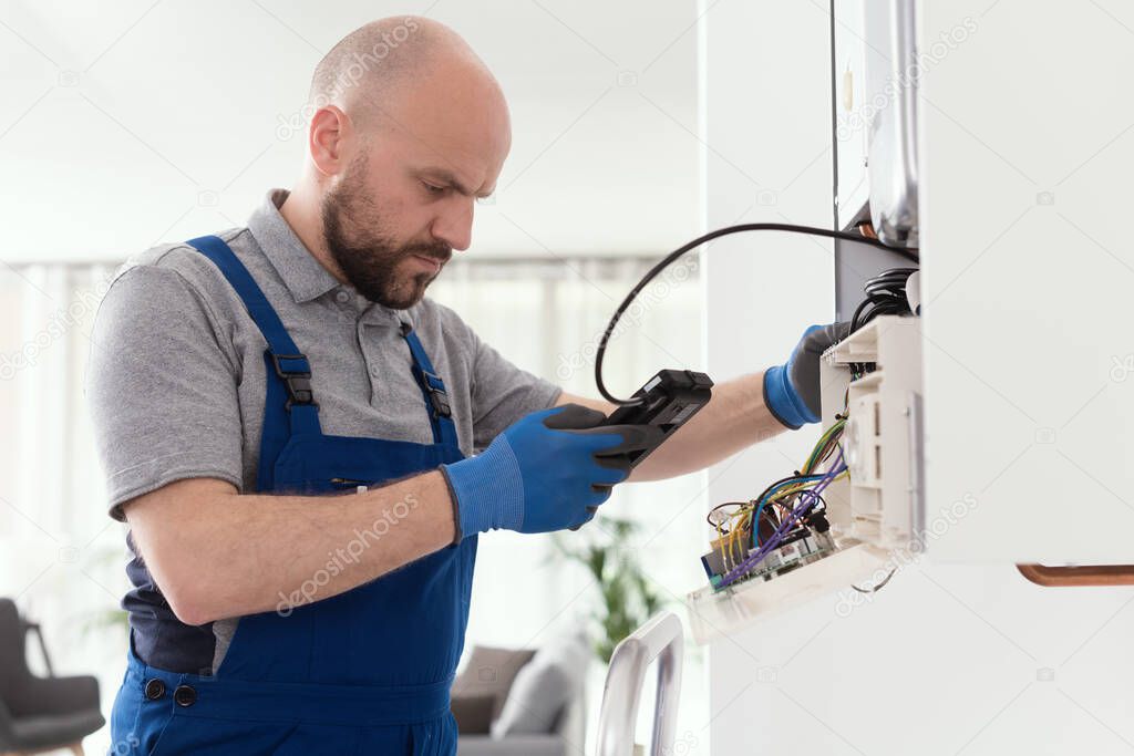 Qualified engineer checking flue gas emissions on a domestic gas boiler using a flue gas analyzer