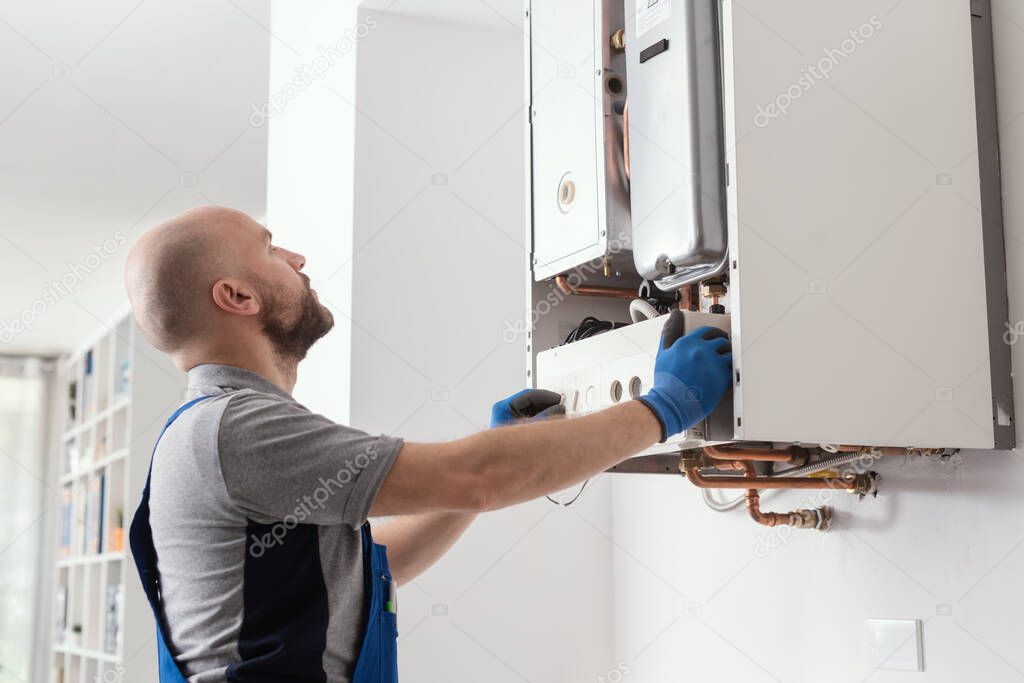 Professional qualified engineer testing a gas boiler after repair