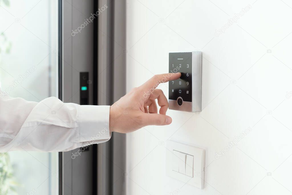 Man setting an alarm code for home security, alarm system concept