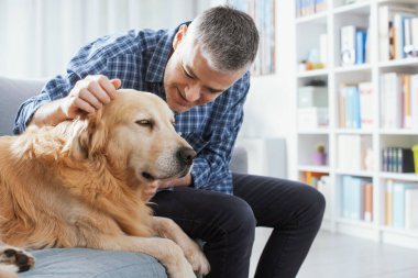 Pet owner spending time with his dog at home in the living room