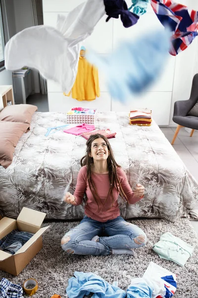 Young Woman Sitting Floor Bedroom Throwing Clothes Air — Stock Photo, Image