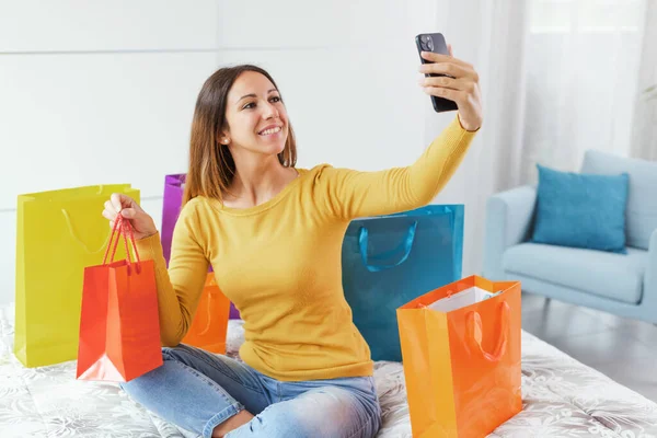 Happy Young Woman Sitting Bed Taking Selfies Her Shopping Bags — Foto Stock