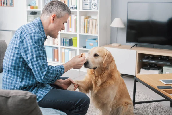 Man Giving Treat His Dog Holding His Paw Training Him — 스톡 사진