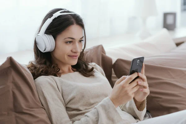 Young Woman Relaxing Bed She Wearing Headphones Watching Videos Her — Stockfoto