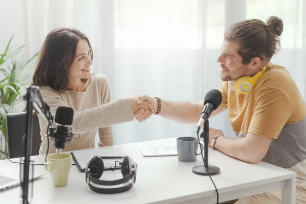 Speaker and guest shaking hands before starting the live streaming podcast, communication and media concept