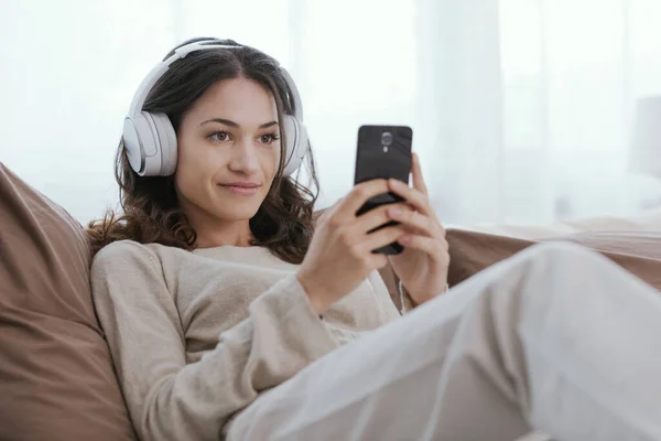 Young Woman Relaxing Bed She Wearing Headphones Watching Videos Her — Stok fotoğraf