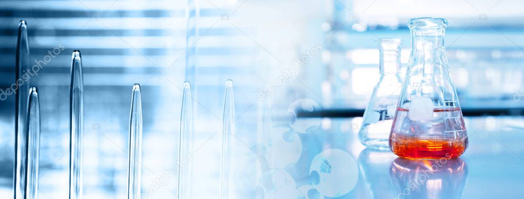 orange solution in science glass flask in blue chemistry research school lab banner background	