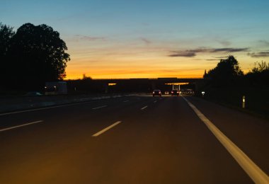 Günbatımındaki otoyol gece görüşü. Trafik ve ulaşım geçmişi..