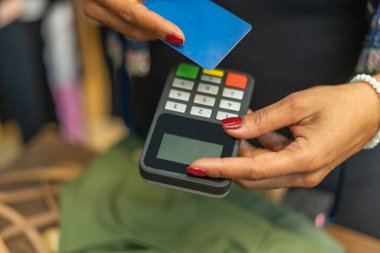 Credit card payment cashless contactless concept.Woman holding machine for customer in shop payment