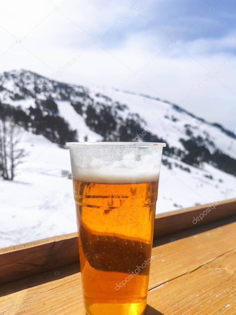 Beer glass on mountains ski resort background