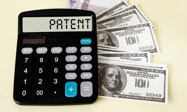 Calculadora Con Texto Patentes Dólares Sobre Fondo Claro — Foto de Stock