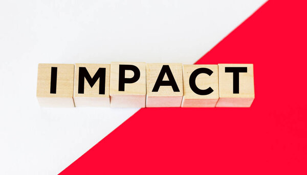 Impact - is a name made of wooden letters. On a red and white background. Information and communication background.