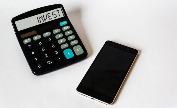 Word在手机白色背景下的计算器显示上投资 金融投资和利润分析或计算概念 — 图库照片