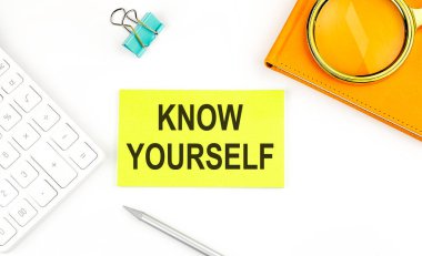 Beyaz arkaplanda, hesap makinesi ve defterin yanında 