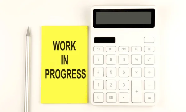 Text Work Progress Yellow Sticker Next Pen Calculator — Stock Photo, Image