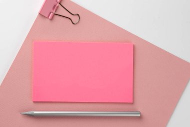 Pembe kağıda pembe etiket ve beyaz arka planda kalem.