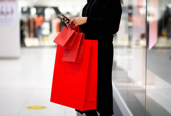 Black Friday, Woman holding red shopping bag on mall background