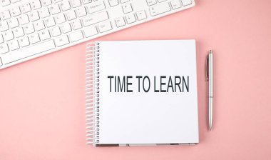 Klavyeli pembe ofis masası, öğrenmek için mesaj zamanı olan not defteri.