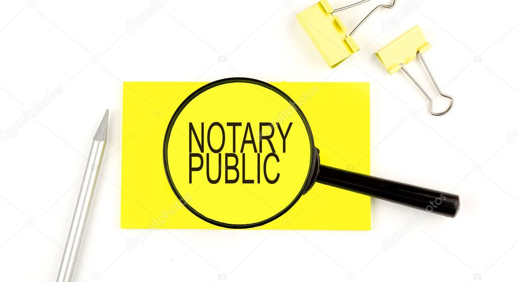 NOTARY PUBLIC text on the sticker through magnifier. View from above. Business