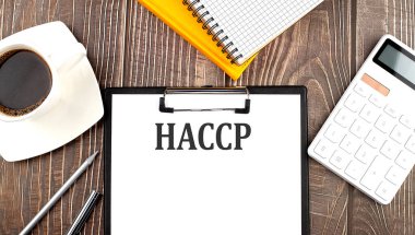 Kahveli, hesap makineli ve defterli HACCP metni. İş dünyası